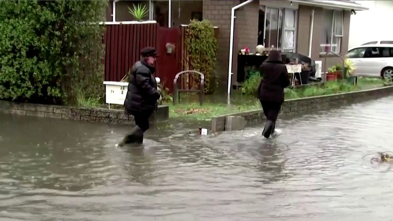 People wade through floodwaters in Canterbury, New Zealand, May 30, 2021, in this still image obtained from a video. TVNZ/via Reuters