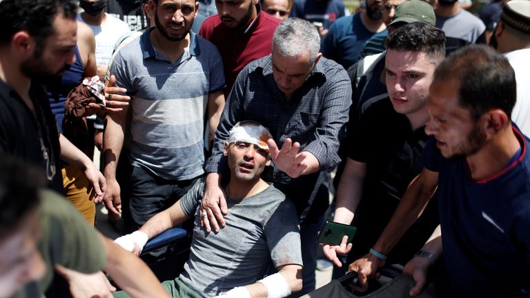 Rescuers help a man pulled from the rubble of a building in Gaza City