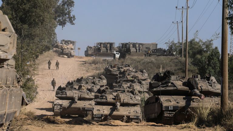 Israeli soldiers assemble with their tanks at the Gaza border