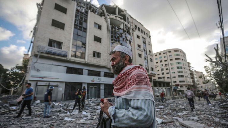 Les gens inspectent les restes d'un bâtiment détruit dans la ville de Gaza