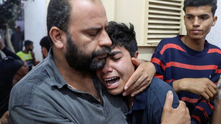 A man in Gaza is comforted after one of his relatives died in the violence