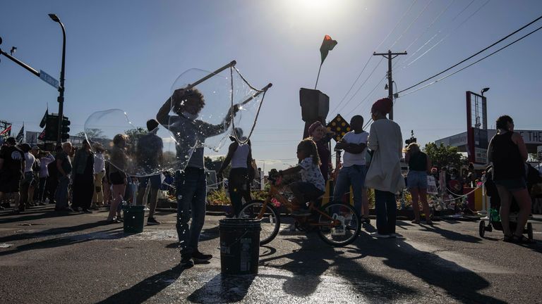 A young boy makes bubbles at the vigil