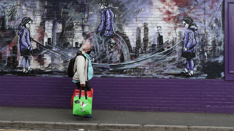 A man passes a mural in a Hartlepool street