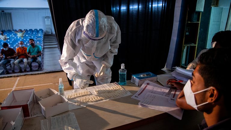 A health worker in PPE performs rapid test for COVID-19. Pic: AP