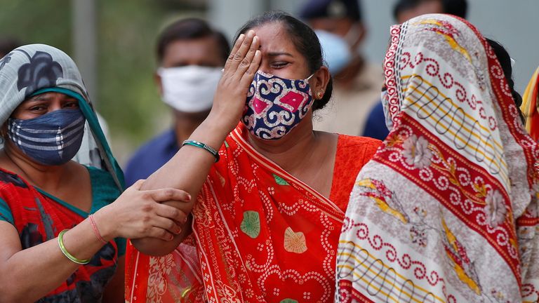 A woman whose husband died from COVID mourns outside a mortuary in Ahmedabad, India