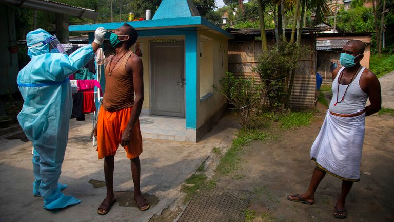 A heath worker takes a nasal swab sample to test in Gauhati, India. Pic: AP