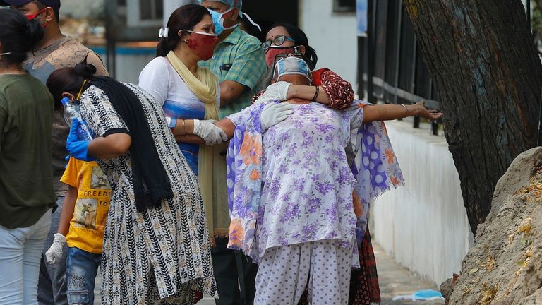 A woman mourns after seeing the body of her son who died after catching COVID-19 in New Delhi, India