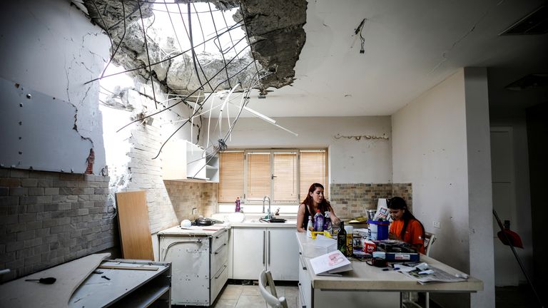 A family in Ashkelon sit in the kitchen of their house damaged by a rocket from Gaza