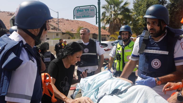 Medics evacuate a person injured after a rocket attack on Ashkelon, southern Israel