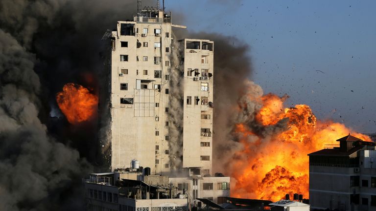 Smoke and flames rise from a tower building as it is destroyed by Israeli air strikes