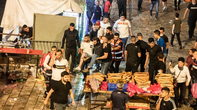 People help an injured man in Sheikh Jarrah district. Pic: AP