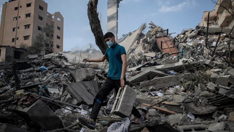 A Palestinian man inspects the damage of a six-story building which was destroyed by an early morning Israeli airstrike, in Gaza City. Pic: AP