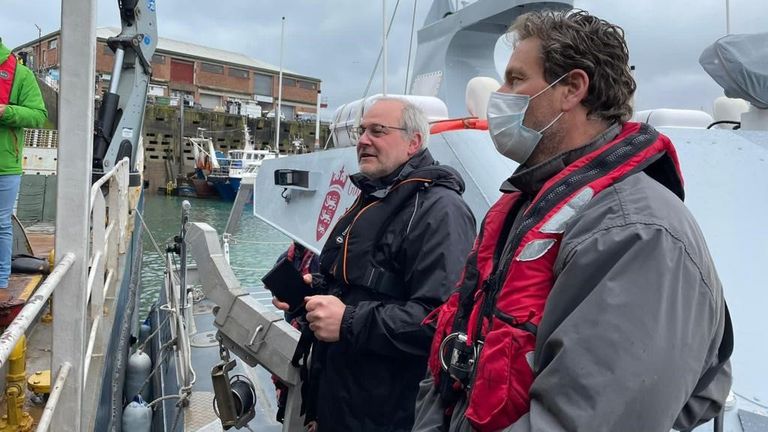 Jersey&#39;s assistant environment minister Gregory Guida (L) spoke to French fishermen from a boat