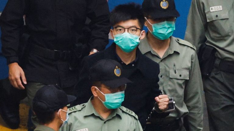 Joshua Wong walking to a prison van in March