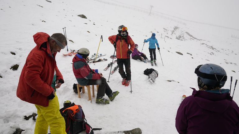 Skiers rest during heavy snowfall at the Lake District Ski Club