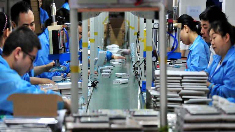 Employees work on a production line manufacturing lithium battery products at a factory in Yichang,