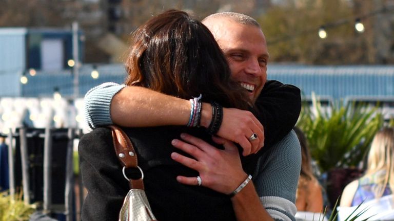 People hug at the Skylight rooftop bar as the coronavirus disease (COVID-19) restrictions ease, in London, Britain April 12, 2021. REUTERS/Dylan Martinez