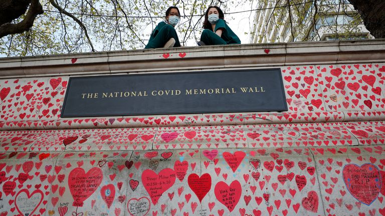 Nurses from the nearby St Thomas hospital have a rest on the National Covid Memorial Wall in London, Tuesday, April 27, 2021. British Prime Minister Boris Johnson has denied a press report which quoted him as allegedly saying he would rather see ...bodies pile high in their thousands... than impose a third national lockdown on the country. The Daily Mail claimed that Johnson made the comment in the fall of 2020, when his government imposed a second lockdown to combat a surge in coronavirus cases. (AP Photo/Frank Augstein)                                                                                                                       