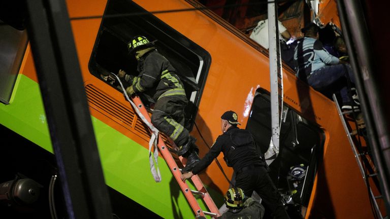 Rescuers work at a site where an overpass for a metro partially collapsed with train cars on it at Olivos station in Mexico City, Mexico May 3, 2021.