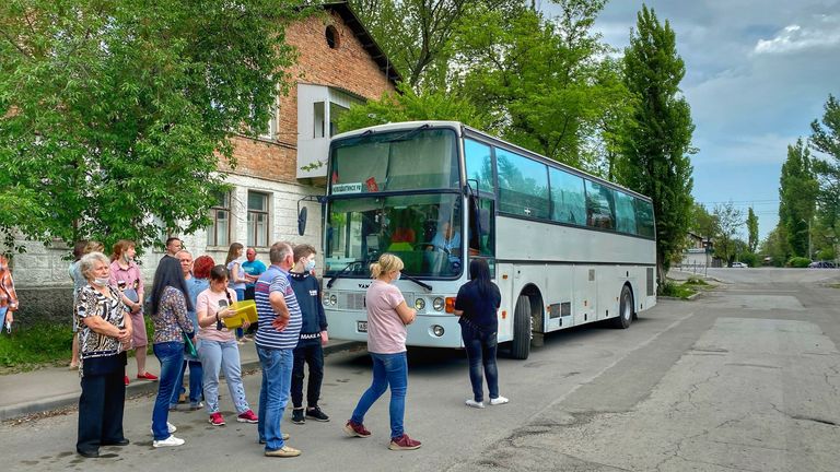 People wait to be called forward to enter a police station to get a Russian passport