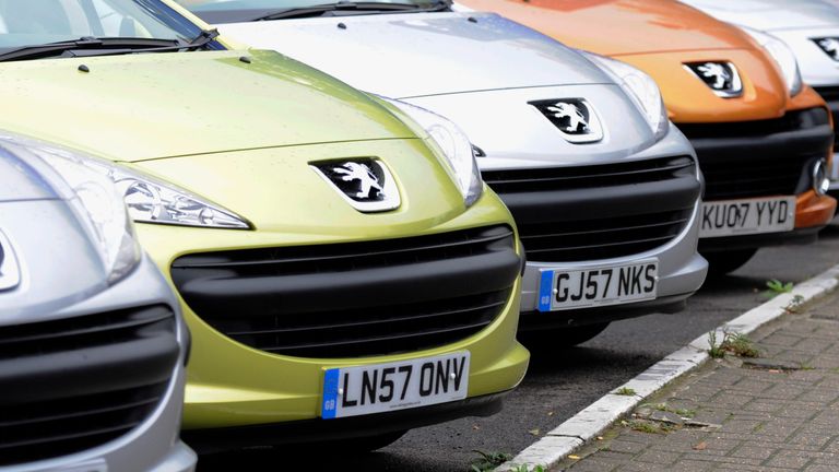 A man passes cars on a showroom forecourt in west London, Britain November 6, 2008