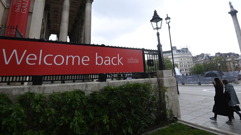 Les gens se protègent de la pluie en passant devant la National Gallery alors que les restrictions sur la maladie à coronavirus (COVID-19) continuent de s'atténuer à Londres, en Grande-Bretagne, le 17 mai 2021