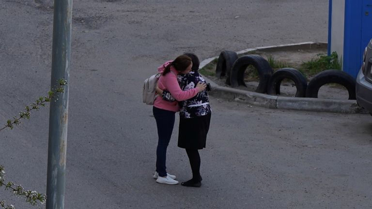 A parent embraces her child outside the school premises. Pic: Max Zareckiy via Reuters