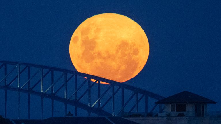 April&#39;s supermoon rises over the Sydney Harbour Bridge in Australia, Tuesday, April 27, 2021. This moon is a supermoon, meaning it appears larger than an average full moon because it is nearer the closest point of its orbit to Earth (AP Photo/Mark Baker)