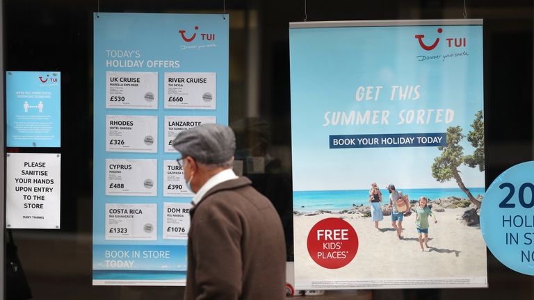 A person makes their way past the shop window of a Tui store in Eastleigh