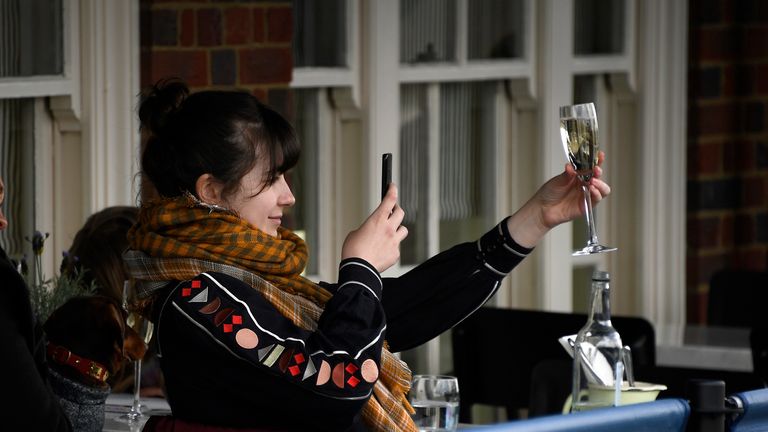 APTOPIX Virus Outbreak Britain
A young woman takes a picture of her drink while sitting at a pub terrace in London, Monday, April 12, 2021. Millions of people in England will get their first chance in months for haircuts, casual shopping and restaurant meals on Monday, as the government takes the next step on its lockdown-lifting road map. (AP Photo/Alberto Pezzali)