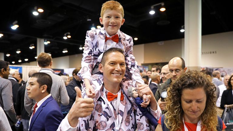 Ray Renk holds his 10-year-old son Benjamin as they wear matching custom-made suits printed with a caricature of Berkshire Hathaway Chief Executive Warren Buffett at the annual shareholder meeting in Omaha, Nebraska, U.S., May 4, 2019