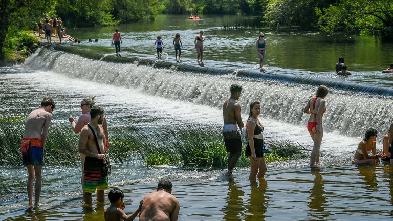 People paddle and swim in Warleigh Weir, Bath