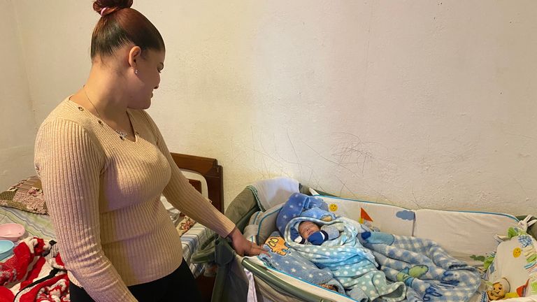 Thais Ferreira de Lomes looks down at her three-month-old baby Ezequiel, who has just been released from hospital