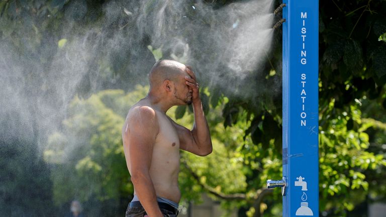 A man cools off at a &#39;misting station&#39; in Vancouver