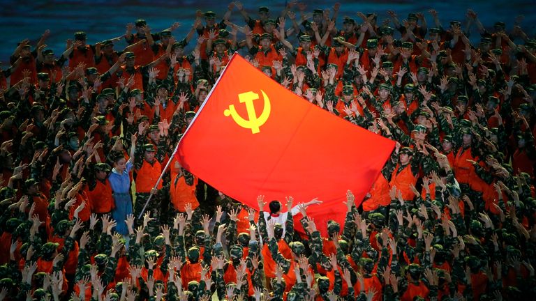 People perform and wave a Chinese national flag on the stage during the Great Conquest to celebrate the 100-year of the Chinese Communist Part at National Stadium, known as Birds&#39; Nest in Beijing 