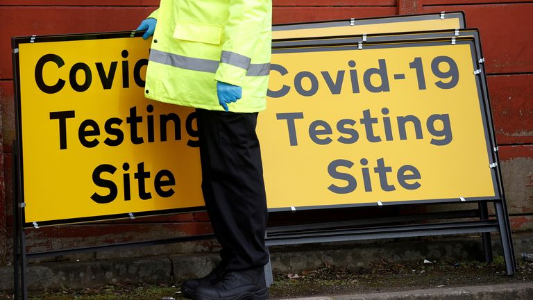 A member of NHS Test and Trace staff sets up a mobile testing centre in the Moston area of Manchester