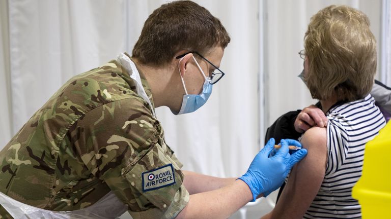 An RAF serviceman gives a dose of a COVID-19 vaccine