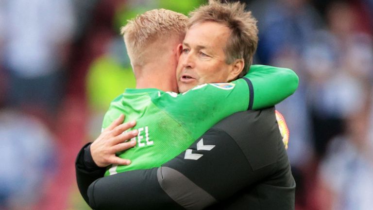 Denmark coach Kasper Hjulmand embraces his goalkeeper Kasper Schmeichel, who has also been praised for his response to what happened to Eriksen