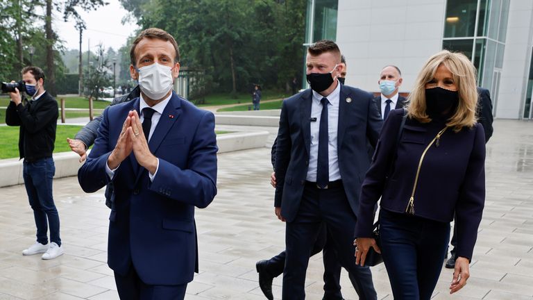 Il presidente francese Emmanuel Macron saluta accanto a sua moglie Brigitte Macron, mentre saluta la gente del posto in un seggio elettorale a Le Touquet, in Francia, durante il secondo turno delle elezioni regionali del 27 giugno 2021. Ludovic Marin / Pool via REUTERS