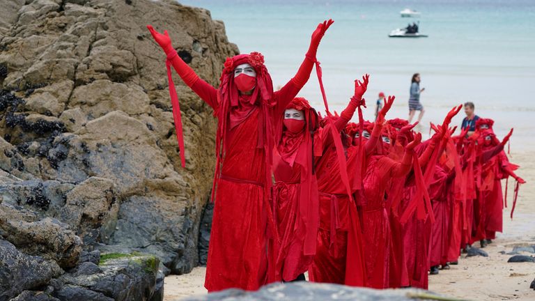 Protestors in costumes march on the beach of Carbis Bay. Pic: AP