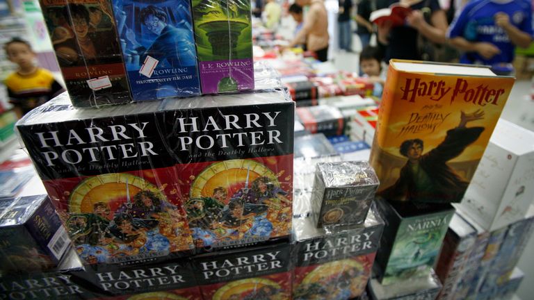 Customers stand next to Harry Potter books at a bookstore in Beijing August 16, 2007. Chinese students have worked their magic on Harry Potter, translating the latest instalment within hours of release of the English version, state media said