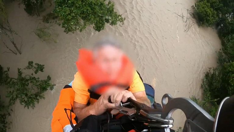 Man being rescued from flood via helicopter rescue