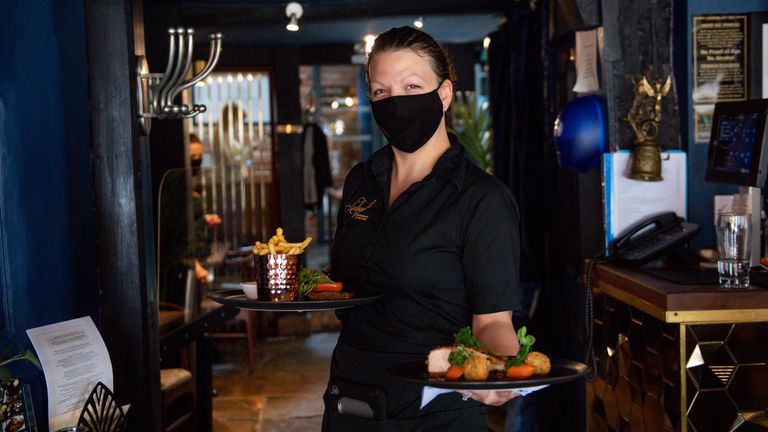 A waitress carries meals to a table during service at Loxleys Restaurant & Wine Bar in Stratford, Warwickshire, as indoor hospitality and entertainment venues reopen to the public following the further easing of lockdown restrictions in England. Picture date: Monday May 17, 2021.