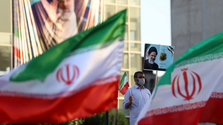 A supporter of Ebrahim Raisi holds a poster of him during an rally in Tehran