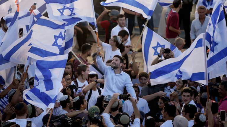 Israeli Knesset members Bezalel Smotrich, center, waves an Israeli flag together with other Jewish ultranationalists during the "Flags March" next to Damascus gate, outside Jerusalem&#39;s Old City, Tuesday, June 15, 2021. (AP Photo/Mahmoud Illean)