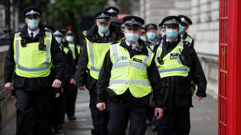 Police attend an anti-lockdown protest in London