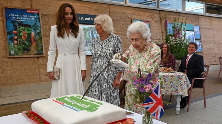 Britain&#39;s Queen Elizabeth attempts to cut a cake with a sword next to Camilla, Duchess of Cornwall, and Catherine, Duchess of Cambridge as they attend a drinks reception on the sidelines of the G7 summit, at the Eden Project in Cornwall, Britain June 11, 2021. Oli Scarff/Pool via REUTERS