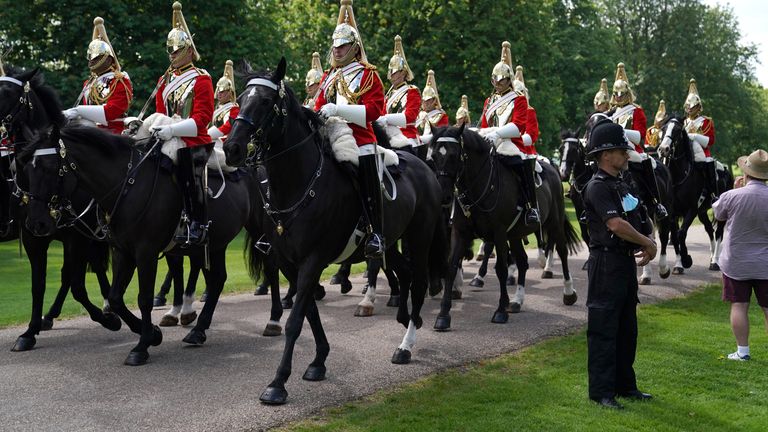Members of the Household Cavalry make their way down the Long Walk towards Windsor Castle 
