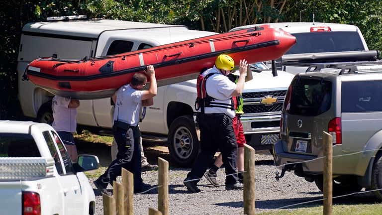 Rescue workers carry a boat near the Dan River during the search for the two missing people 