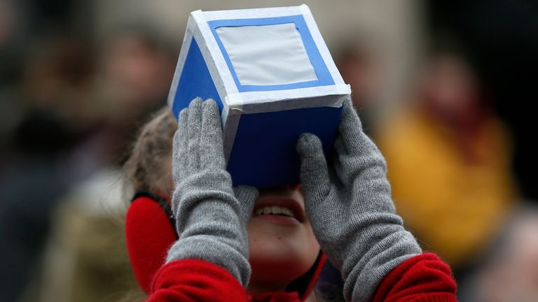 A girl holds a home-made protective viewing box outside The Royal Observatory during a partial solar eclipse in Greenwich, south east London March 20, 2015. REUTERS/Stefan Wermuth